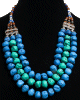 Collier fantaisie imitation pierres bleues turquoises et perles agencees par des armatures argentees ciselees